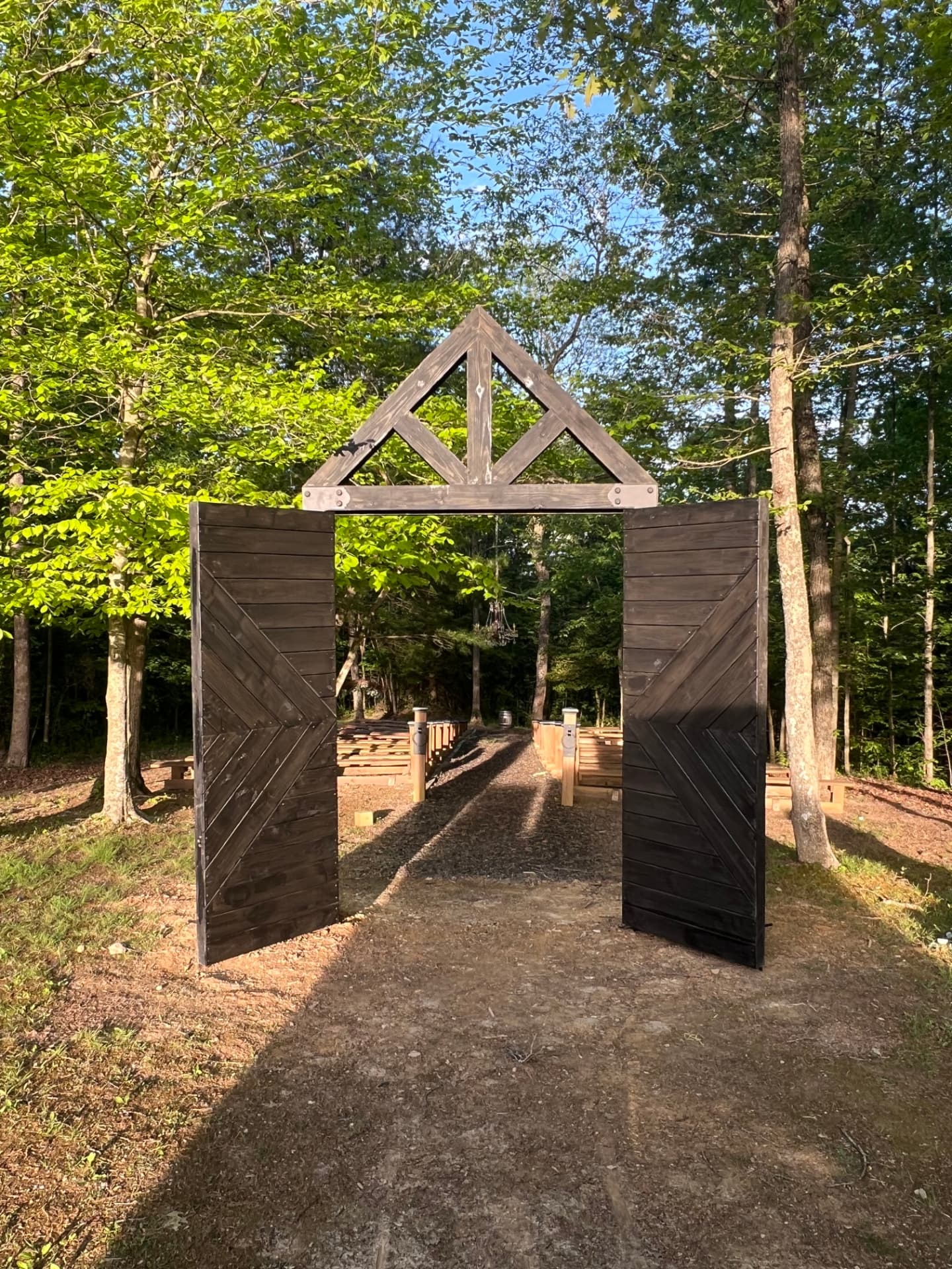 Handcrafted timber entry gate at a wooded outdoor venue
