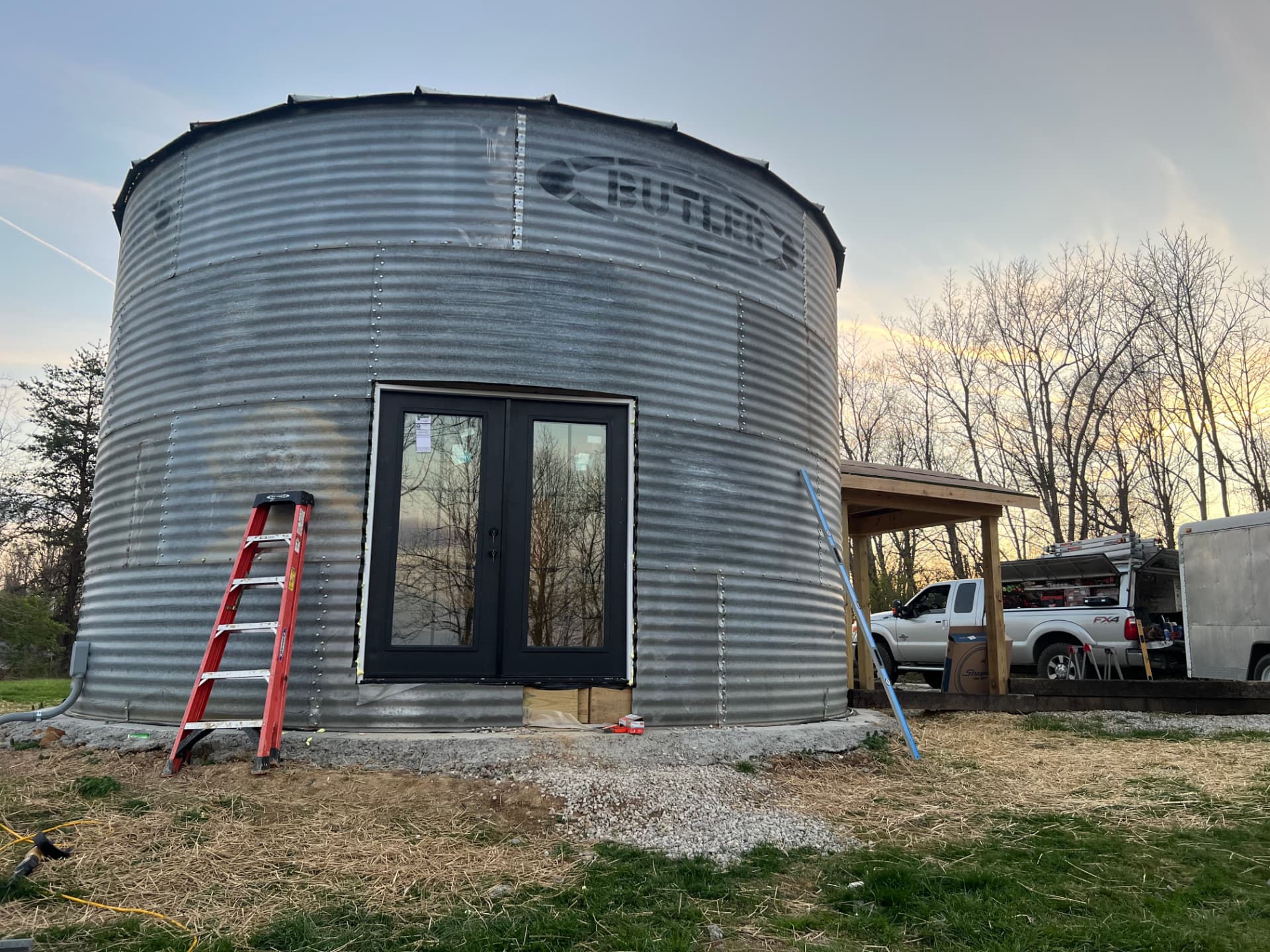Grain silo converted into a building with new black French doors by CM Services LLC
