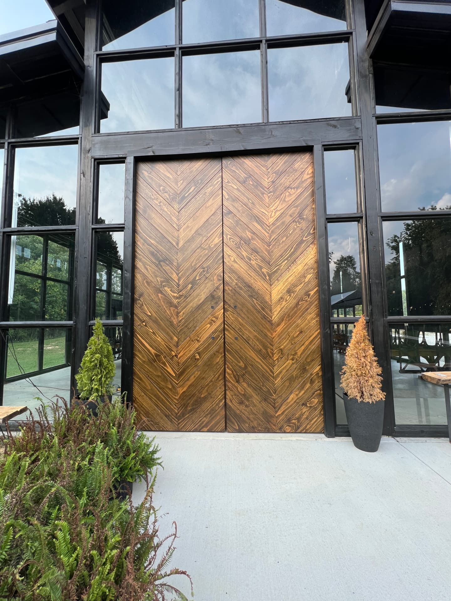 Custom chevron wood double doors in a black timber frame